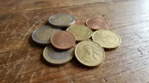 Monete in euro sparse su un tavolo di legno, tra cui centesimi e tagli utili per riconoscere un 10 centesimi raro