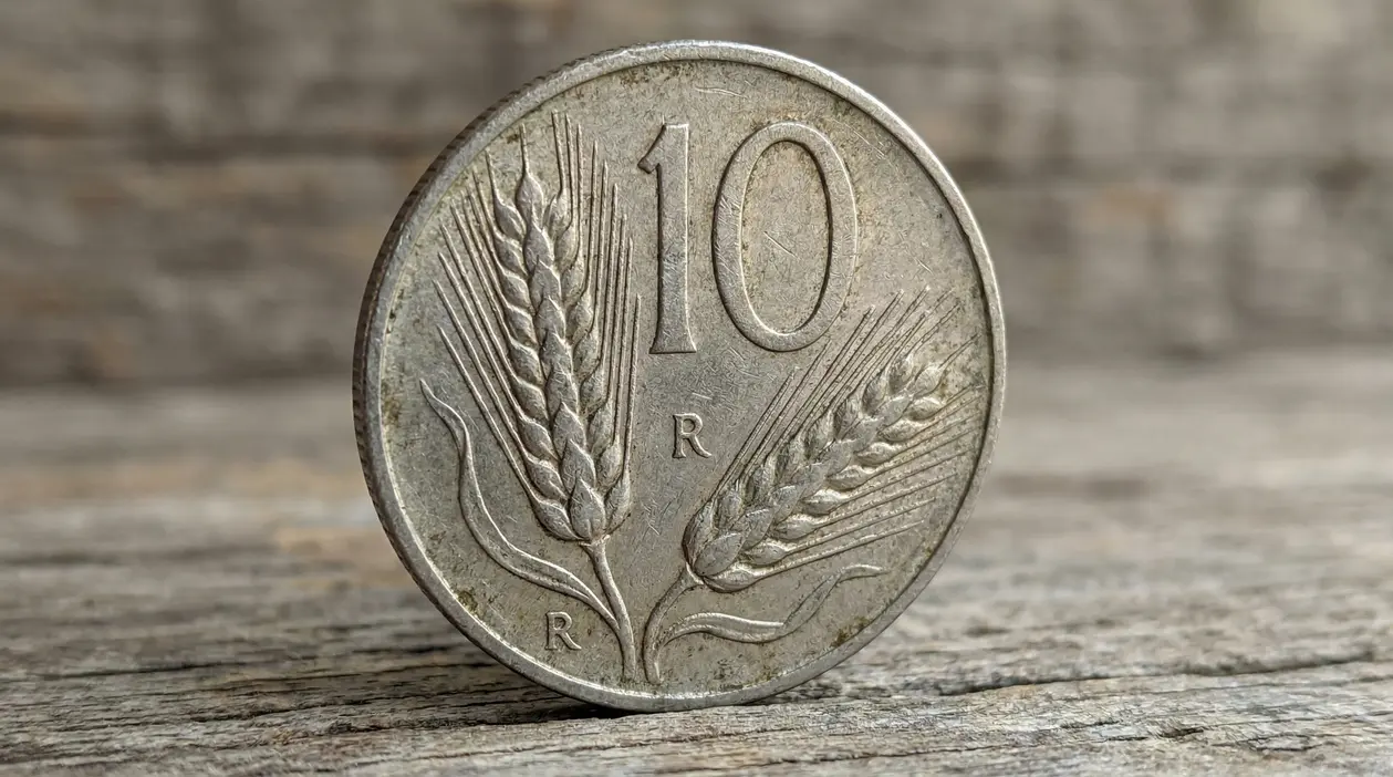 Primo piano di una moneta italiana da 10 lire Spiga appoggiata su una superficie di legno