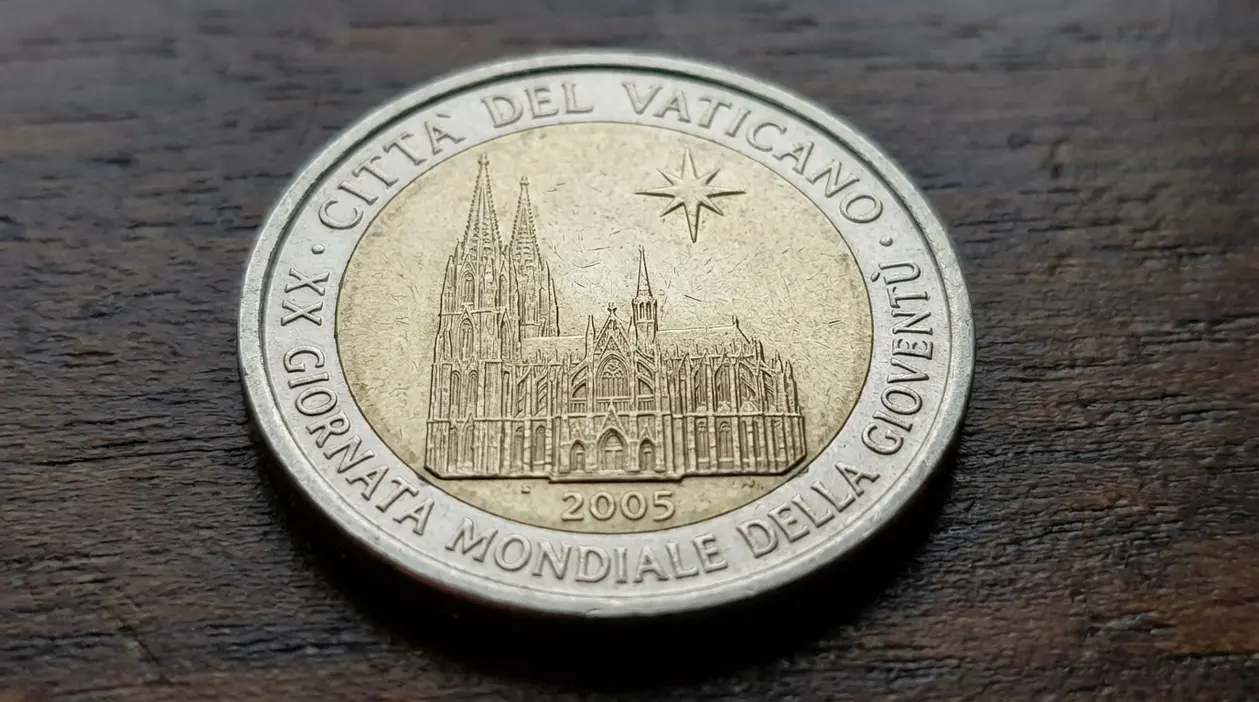 Moneta da 2 euro Vaticano 2005 commemorativa, fotografata in primo piano su una superficie di legno