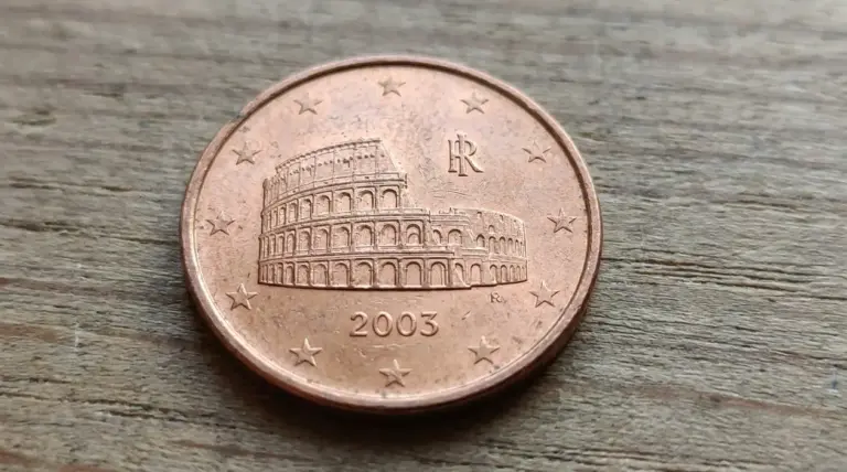 Moneta italiana da 5 centesimi del 2003 con il Colosseo, fotografata in primo piano su una superficie di legno