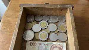 Monete italiane in lire dentro un cassetto di legno, con alcune 500 lire in evidenza