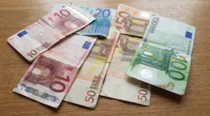 Banconote in euro usurate e spiegazzate appoggiate su un tavolo, tra cui 10, 20, 50 e 100 euro