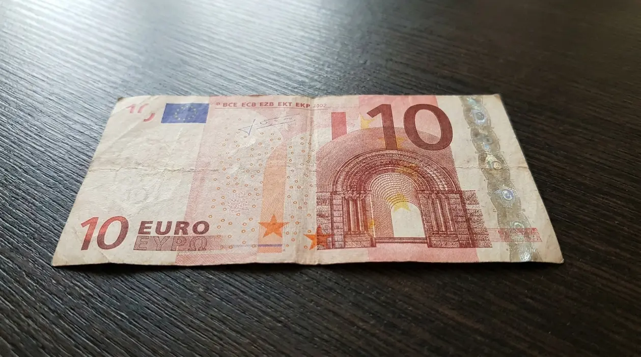 Banconota da 10 euro usurata appoggiata su un tavolo, legata al tema della prossima dismissione