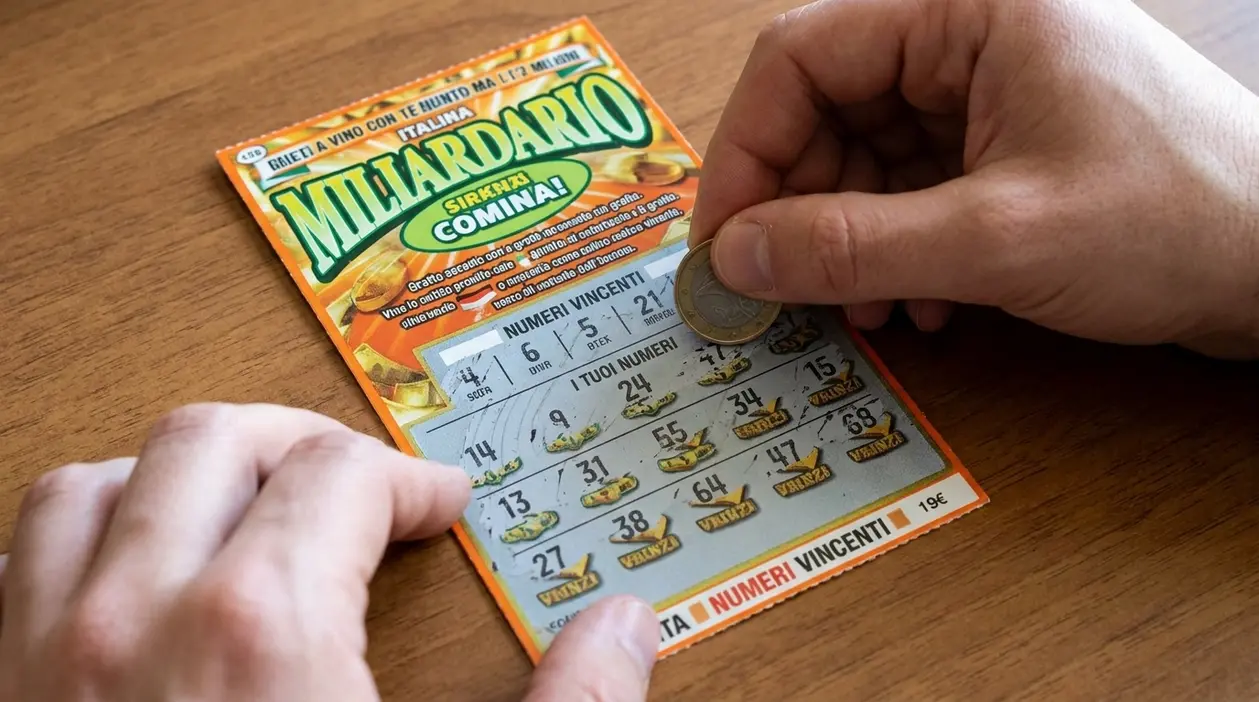 Mani che grattano un biglietto Gratta e Vinci su un tavolo di legno con una moneta