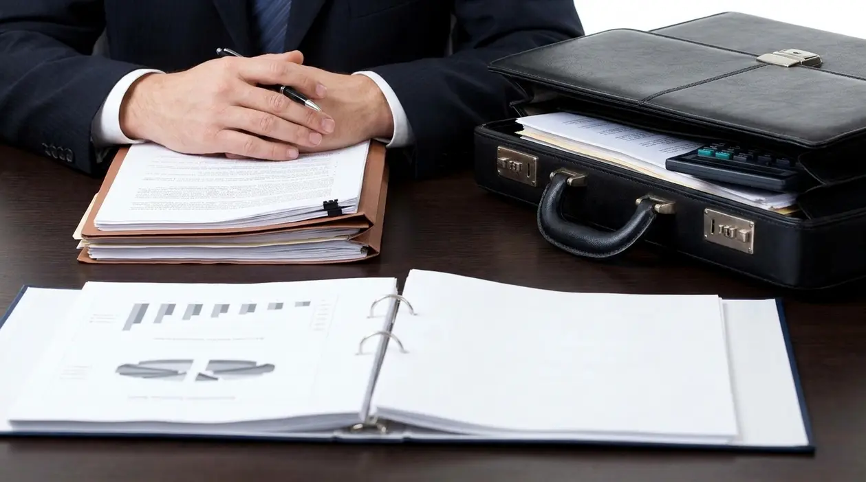 Professionista in ufficio con documenti e valigetta, simbolo di fallimento aziendale e responsabilità di soci e amministratori