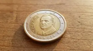 Moneta da 1 euro spagnola del 2024 con ritratto maschile appoggiata su una superficie di legno