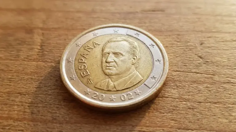 Moneta da 1 euro spagnola del 2024 con ritratto maschile appoggiata su una superficie di legno