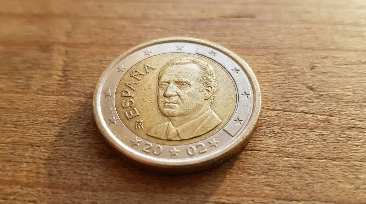 Moneta da 1 euro spagnola del 2024 con ritratto maschile appoggiata su una superficie di legno