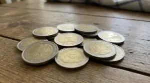 Mucchio di monete da 2 euro su un tavolo di legno, simbolo delle emissioni commemorative di valore