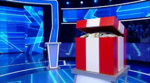 Pacco rosso e bianco aperto con denaro su un set televisivo, simbolo dei premi nei game show