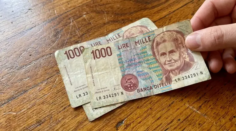 Mano che tiene alcune banconote da 1000 lire con Maria Montessori su un tavolo di legno